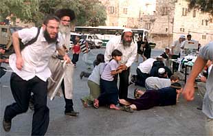 Judíos ultraortodoxos corren tras los disparos de un palestino en las fiestas del Succot, en Hebrón.