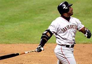 Barry Bonds sigue con la vista la pelota tras  batear  su 70º  home run  en una sola temporada.
