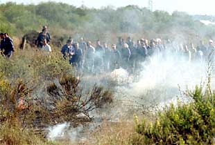 Trabajadores de Izar, ayer, tras unos matorrales que quemaron cerca del puente Carranza de Cádiz.