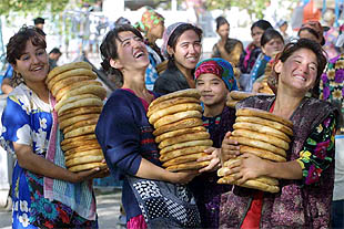 Varias mujeres transportan pan en el mercado de la ciudad uzbeka de Termez, junto a la frontera con Afganistán.