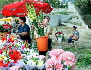 Tres vendedoras de flores, ayer a la puerta del cementerio de Montjuïc.