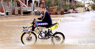Un motorista cruza una calle anegada por las lluvias en Los Alcázares (Murcia).