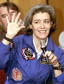  ANIVERSARIO EN LA ISS.  Al cumplirse ayer un año de habitación permanente de la Estación Espacial Internacional, tripulada actualmente por dos rusos y un estadounidense, la francesa Claude Haigniére, recién llegada de la ISS, muestra un euro que llevó al espacio.