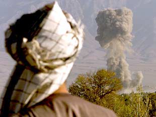 Un combatiente de la Alianza del Norte observa la explosión de un proyectil a unos 30 kilómetros de Kabul.