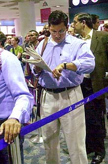 Pasajeros de un vuelo de American Airlines hacen fila para embarcar en el aeropuerto internacional de Miami.