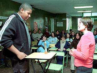 Maribel enseña a uno de los jóvenes a colocar un condón.