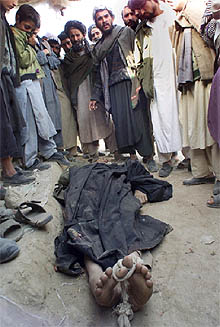 Un grupo de habitantes de Kunduz rodea el cadáver de un talibán.