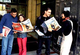 Alumnos de la Hispalense hojean el nuevo  Tentaciones  en la puerta del Rectorado de Sevilla.