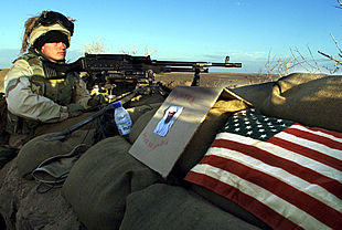 Un  marine , apostado en una trinchera al sur de Afganistán, junto a una fotografía de Osama Bin Laden con la leyenda: 'Se busca vivo o muerto'.