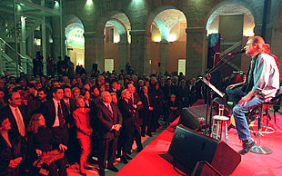 Los asistentes a la fiesta de la Constitución escuchan a Luis Eduardo Aute en la Real Casa de Correos, sede del Gobierno regional.