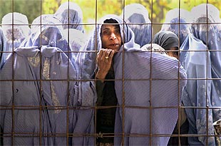 Una mujer afgana se levanta el   burka  y le dice al fotógrafo: 'No necesitamos fotos, necesitamos comida', en Herat. Las mujeres esperan ayuda humanitaria.