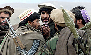 Varios combatientes antitalibanes escuchan a través de radioteléfono las indicaciones de sus mandos, situados en las montañas de Tora Bora.