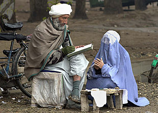 Un escriba de Herat redacta una carta para una mujer con  burka .