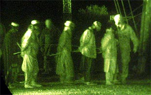    Marines  estadounidenses conducen a prisioneros talibanes a un campo de prisioneros en Kandahar.