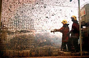 Tareas de extinción del incendio en los almacenes de la papelera Reno de Medici, en el Prat de Llobregat.