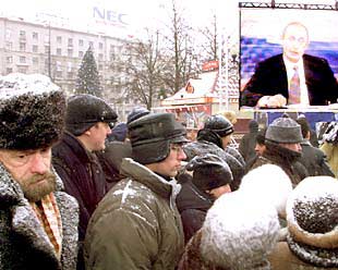 Ciudadanos rusos observan en una pantalla en el centro de Moscú al presidente Putin.