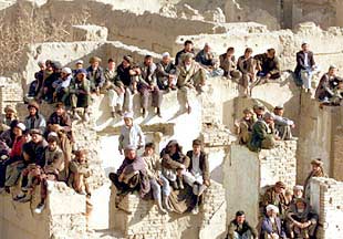 Seguidores del líder tribal Karim Jalili asisten a un mitin sentados sobre las  ruinas de una casa de Kabul.