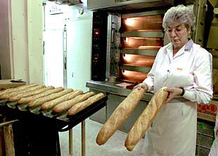 Clara Orio muestra unas barras de pan fermentadas en exceso por el corte de luz sufrido en su establecimiento.