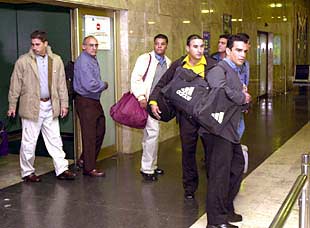 Varios de los cubanos llegados a Madrid abandonan la sala de retenidos de Barajas.