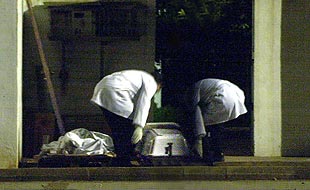 Empleados de la funeraria, ayer, en el momento de retirar los dos cadáveres.