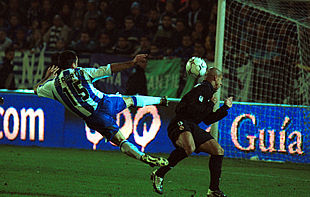 Gerardo intenta un remate ante la oposición de Roberto Carlos.