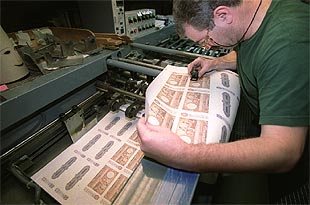 Un empleado de la Fábrica de la Moneda examina la calidad de las reproducciones.