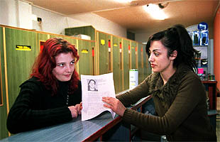 Inma López, junto a Roque Celine, compañera sentimental de Christopher Berarducci, muestra un pasquín de apoyo al detenido.