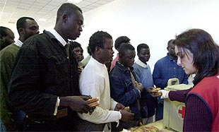 Voluntarios de Cruz Roja reparten comida entre los subsaharianos llegados ayer a Tarifa.