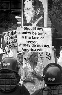 Una mujer protesta contra EE UU con una frase de Bush.