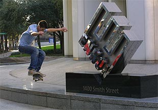 Un joven pasa con su monopatín ante el logotipo de Enron, en la sede de la compañía en Houston.