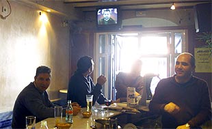 Vecinos de Valverde del Camino ven la noticia sobre José Mantero en la televisión de un bar.