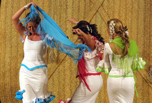 Tres mujeres desfilan en el salón de la moda flamenca.