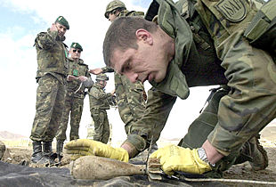 El sargento Gelo, miembro del contingente español, examina una granada sin explotar en las afueras de Kabul.