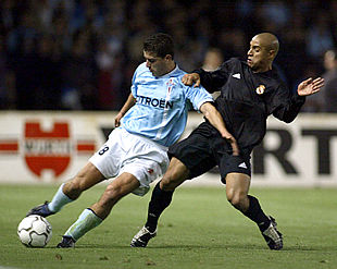 Roberto Carlos presiona a Coira para que no pueda pasar el balón con soltura.