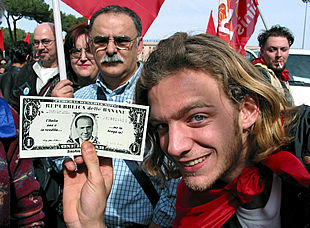 Un manifestante muestra un dólar con el rostro de Berlusconi, en el que se lee: 'República bananera'.