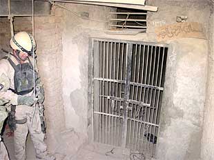 Un  marine  de EE UU, en una celda de prisioneros excavada en el interior de una cueva al este de Afganistán.