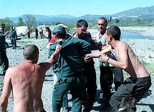 Un guardia civil es zarandeado por un grupo de jóvenes asistentes a la fiesta    hippy  de Órgiva, en Granada.