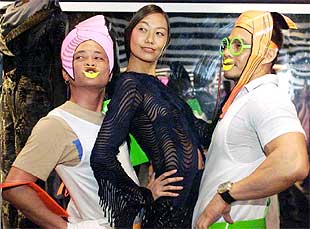 Una modelo de Jean-Paul Gaultier, en el centro, posa con dos asistentes a la muestra del diseñador francés.