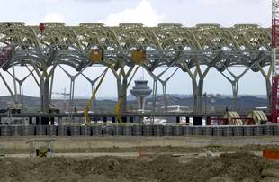 Vista de las obras de las futuras zonas de tránsito, con la torre de control al fondo, de que dispondrán las nuevas instalaciones de la ampliación del aeropuerto de Barajas.