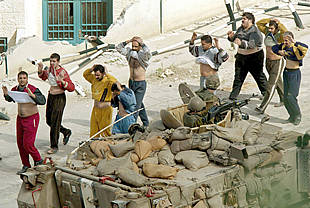 Varios palestinos se rinden en la salida de la alcazaba de Nablús y muestran que no llevan bombas pegadas al cuerpo.