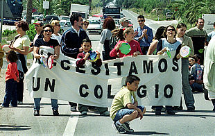 Padres y alumnos de L'Alfàs del Pi, ayer, mientras cortaban el tráfico de la nacional en protesta por la falta de colegios públicos.