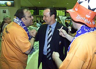 Dos seguidores dan  consignas  a Rafa Benítez, entrenador del Valencia, recién llegado al aeropuerto de Málaga.
