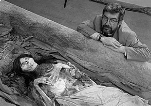 El arqueólogo Guillermo Cock posa con una réplica de una momia, bautizada como    La Señorita. 