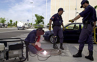 Varios agentes sueldan la tapa de registro de una alcantarilla cercana a la sede de la cumbre  UE-América Latina.