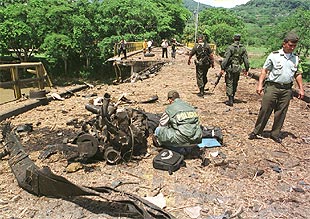 Policías colombianos examinan los restos de un coche bomba colocado por las FARC en La Pintada.