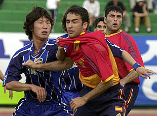 Un defensa coreano marca severamente a Raúl.