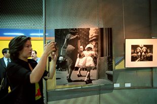 Una mujer hace fotografías en la exposición  La condición femenina. España 1950-2000 , en la parada de metro de Canal.