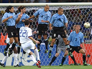 Micoud lanza una falta ante los jugadores de Uruguay.