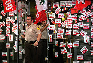 Guardias de seguridad privada cierran las puertas de un establecimito comercial en Madrid.