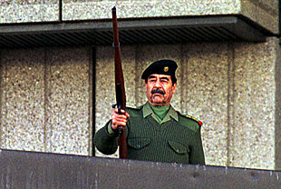 Sadam Husein dispara un fusil al aire durante un desfile militar en Bagdad en noviembre de 2000.